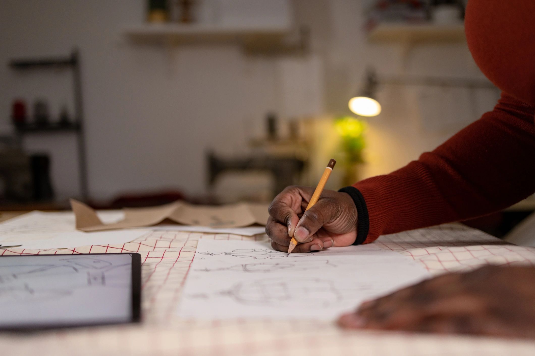 Fashion designer sketching jacket designs in a studio