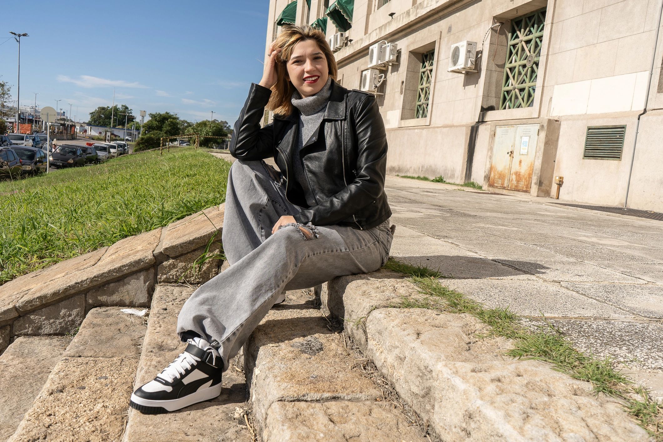 Stylish woman sitting outdoors in an urban setting